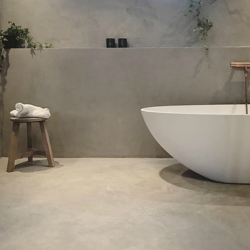 Badrum i Gråbeige microcement – fristående, badkar, kopparkran