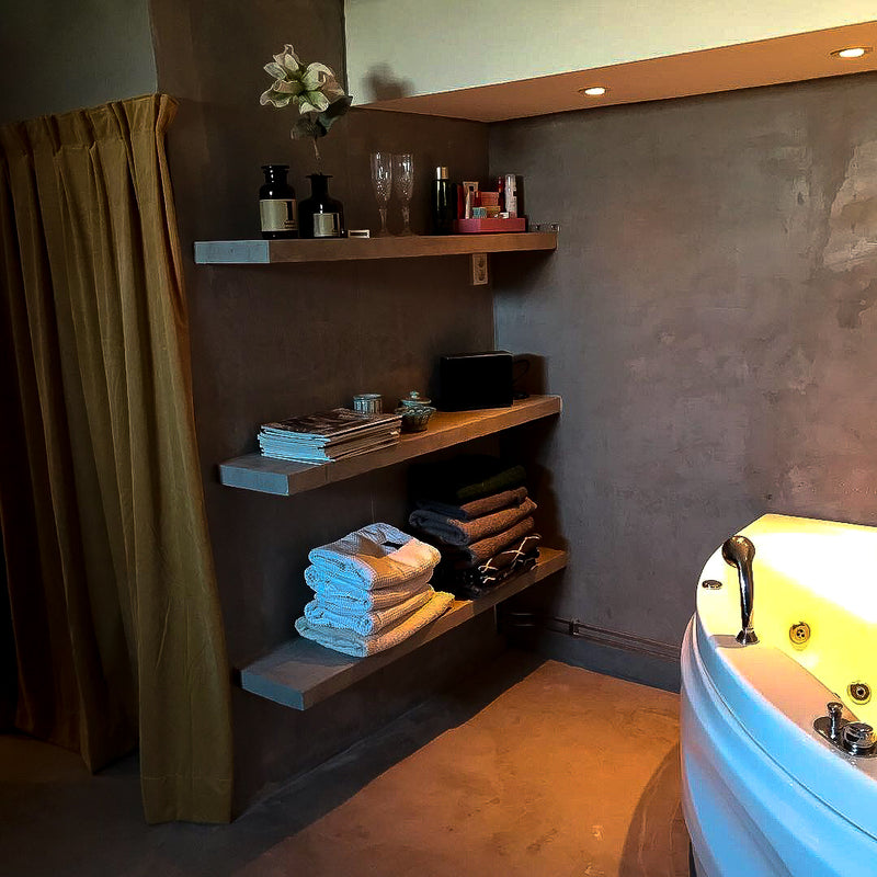 Badrum i Mörkgrå microcement – hylla, jacuzzi, guldgardin