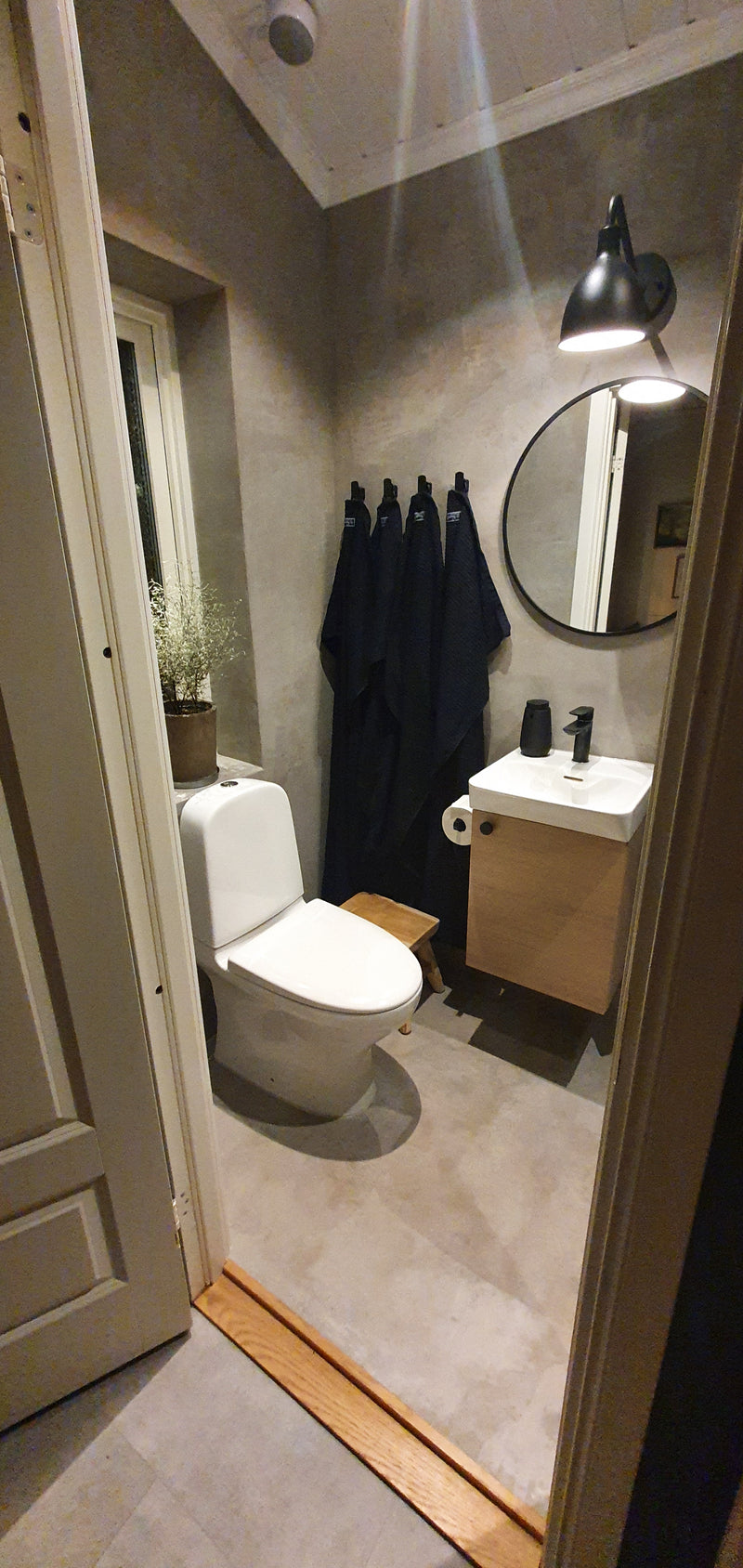 Badrum i Gråbeige microcement – toalett, handfat, paraplyer