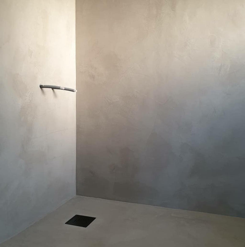 Badrum i Ljusgrå microcement – tomt, duschutrymme, hörnvägg