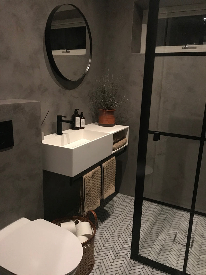 Badrum i mörkgrå microcement – handfat, ovanifrån
