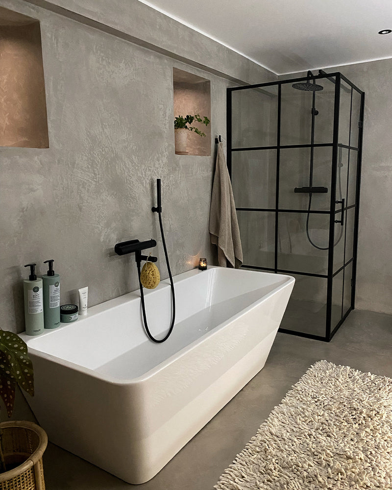 Badrum i ljusgrå microcement – badkar, dusch