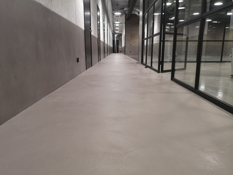 Golv i mörkgrå microcement – korridor, glasvägg