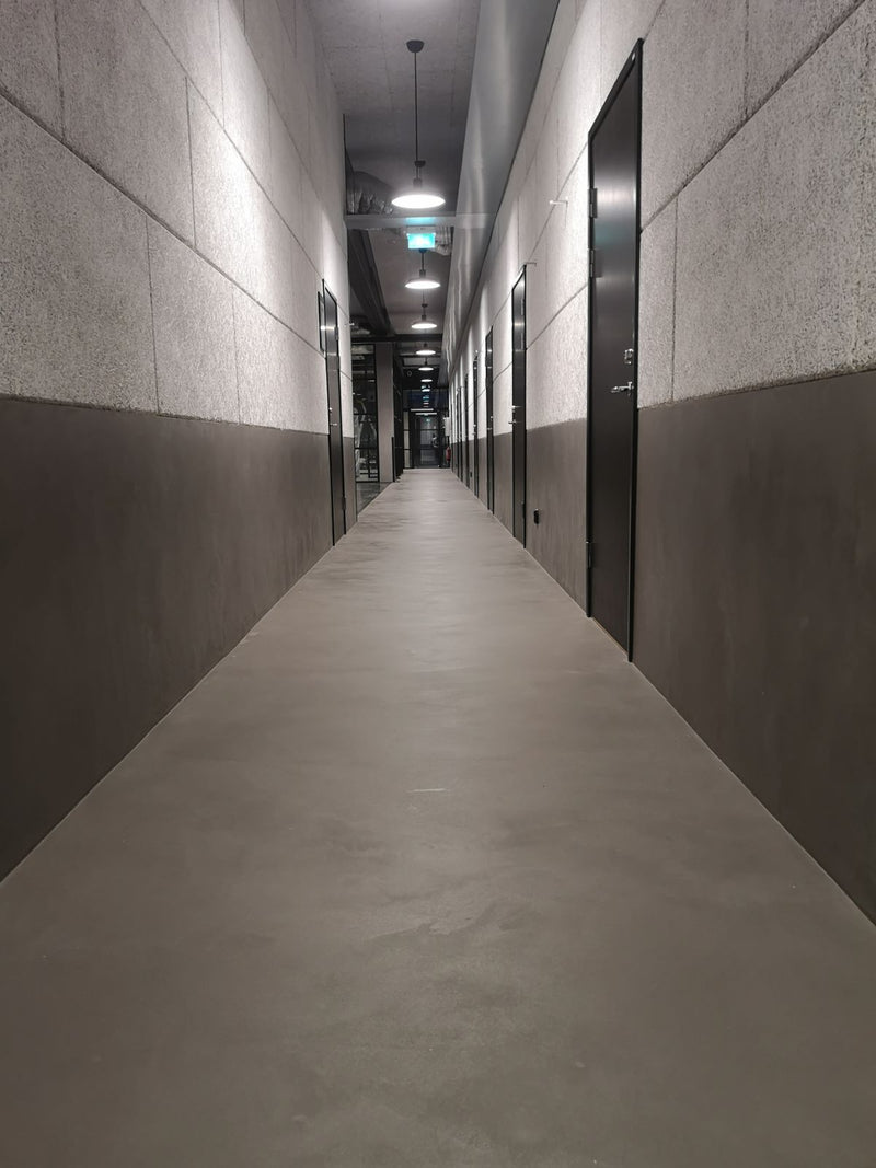 Golv i mörkgrå microcement – korridor, rakt perspektiv