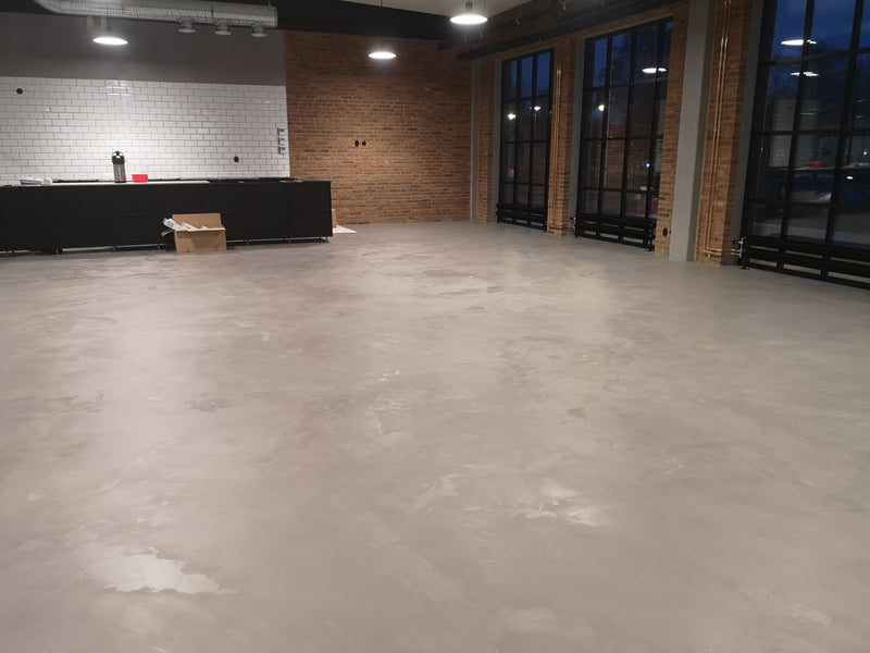Golv i betonggrå microcement – lokal, tomt rum, fönster