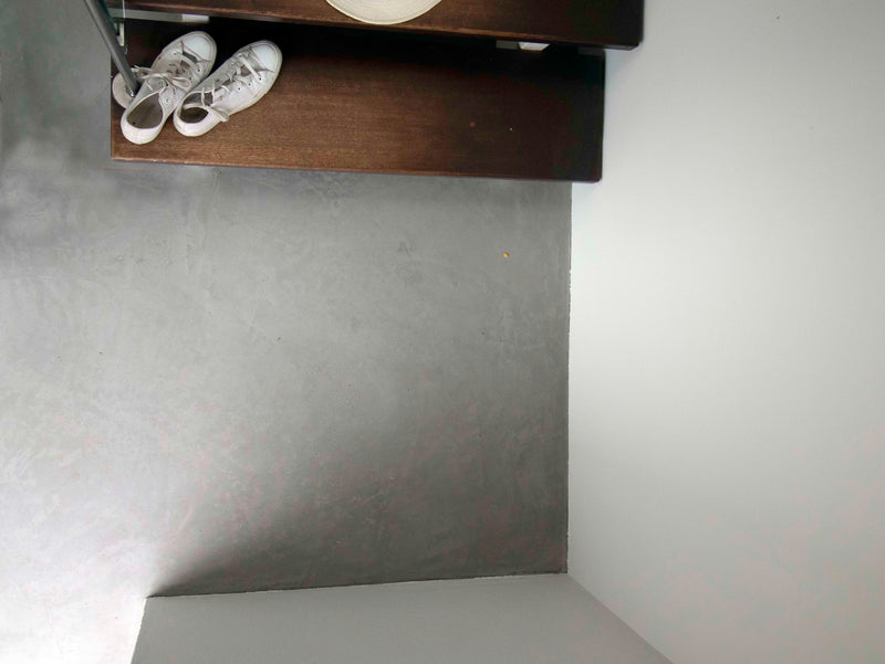 Golv i ljusgrå microcement – hall, skohylla, ovanifrån