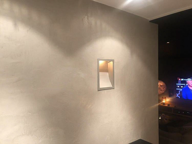 Vägg i gråbeige microcement – vägglampa, detalj