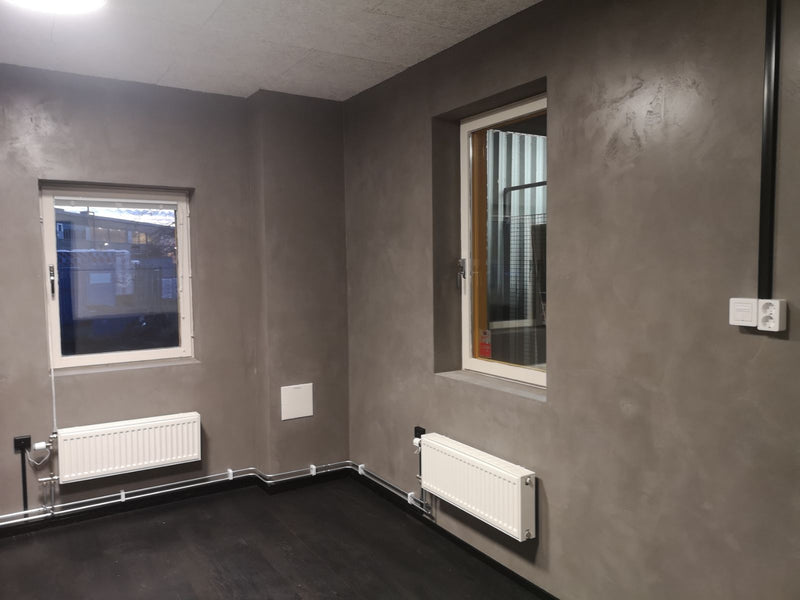 Vägg i mörkgrå microcement – fönster, element, hall