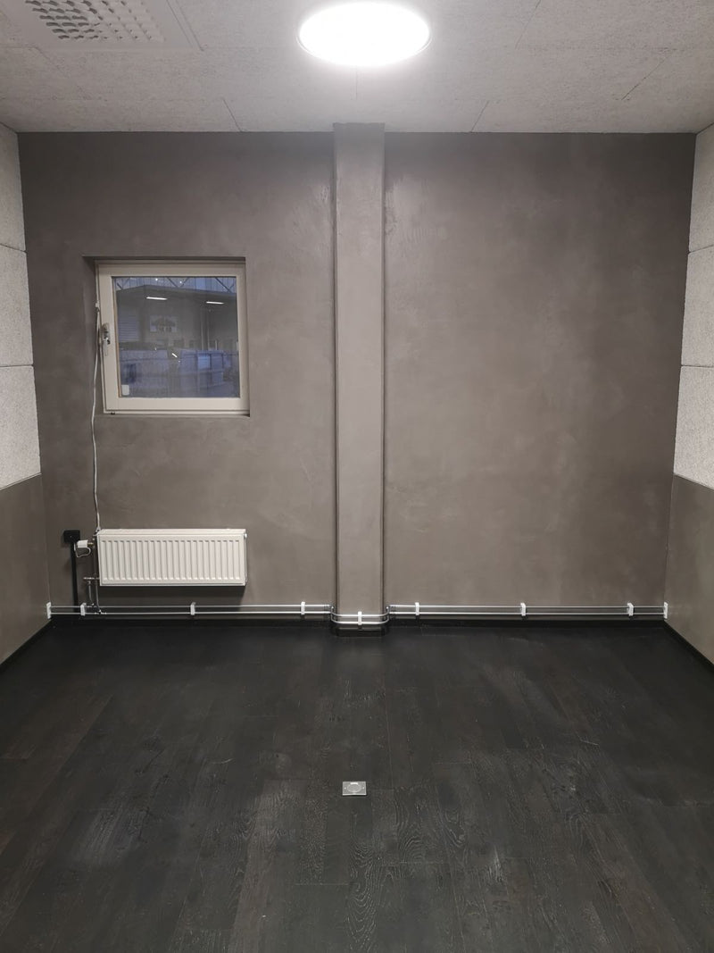 Vägg i mörkgrå microcement – fönster, element, rum