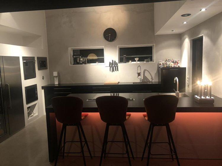 Kök i svart microcement – bardisk, rött ljus