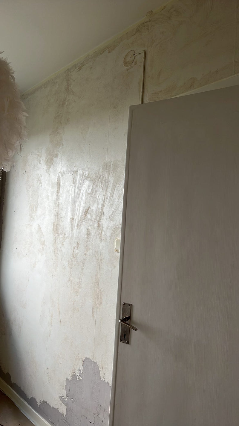 Interiör i betonggrå microcement – dörr, obehandlad vägg