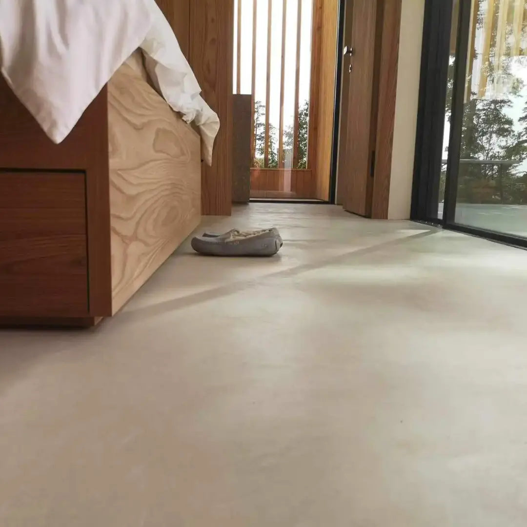 Fogfritt microcement-golv i sovrum med varm betongkänsla