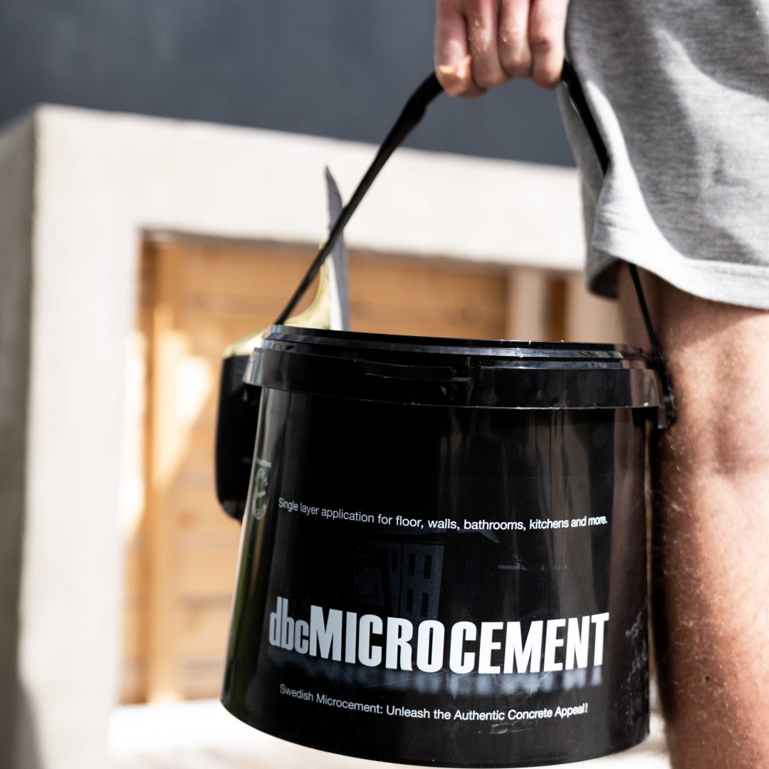 håller hink med microcement från designbycement